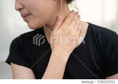 Asian woman touching her pain neck and throat for thyroid gland problem. Asian woman touching her pain neck and throat for thyroid gland problem. 139222353