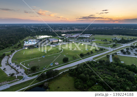 People playing soccer game on illuminated public stadium at sunset. Active way of life concept People playing soccer game on illuminated public stadium at sunset. Active way of life concept 139224188