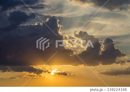 Panorama of sky at sunrise or sunset. Beautiful view of dark blue clouds lit by bright orange yellow sun on clear sky. Beauty and power of nature, meteorology and climate changing concept. Panorama of sky at sunrise or sunset. Beautiful view of dark blue clouds lit by bright orange yellow sun on clear sky. Beauty and power of nature, meteorology and climate changing concept. 139224198