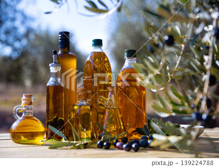 Olive oil on wooden table on background of olive tree 139224788