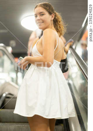 Young woman standing on escalator in subway Young woman standing on escalator in subway 139224829