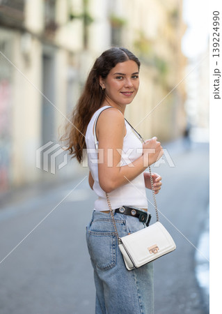 Young smiling girl walks along city street Young smiling girl walks along city street 139224990