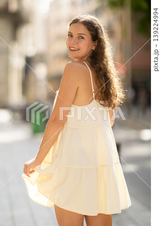 Young woman walks along city street Young woman walks along city street 139224994