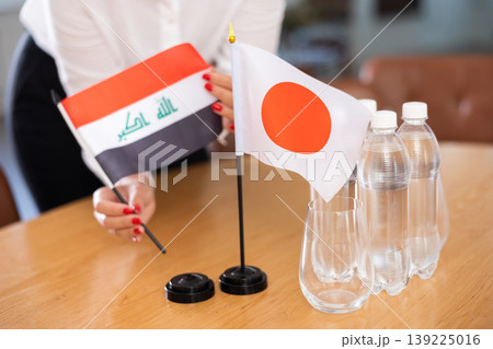 Flags of Iraq and Japan as symbol of diplomatic relations on negotiating table 139225016