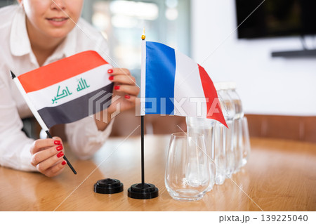 Flags of Iraq and France stand on negotiating table in office Flags of Iraq and France stand on negotiating table in office 139225040