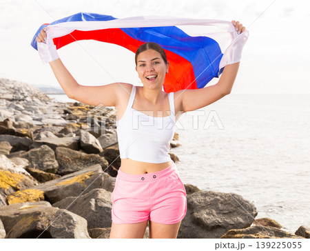 National flag of Russia. Beautiful woman with Russia flag on beach. 139225055