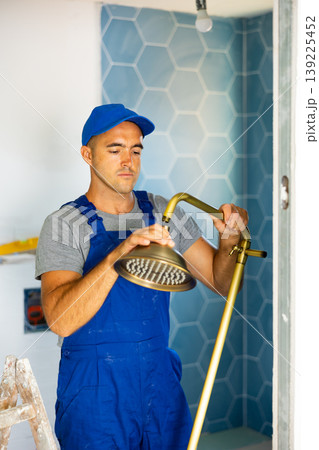 Plumbing specialist assembling tubes of shower in bathroom Plumbing specialist assembling tubes of shower in bathroom 139225452
