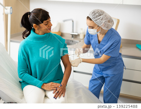 Female nurse vaccinating patient 139225488