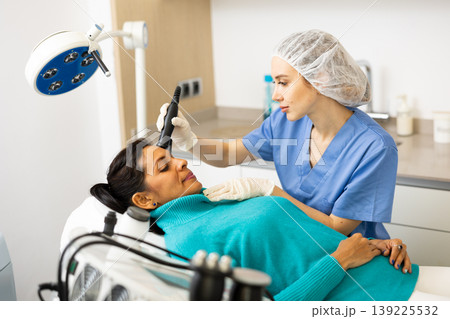 Doctor making rejuvenation electroporation procedure on face Doctor making rejuvenation electroporation procedure on face 139225532