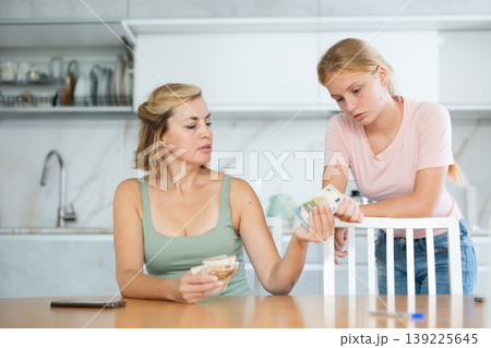Woman received salary giving pocket money to teenage daughter Woman received salary giving pocket money to teenage daughter 139225645