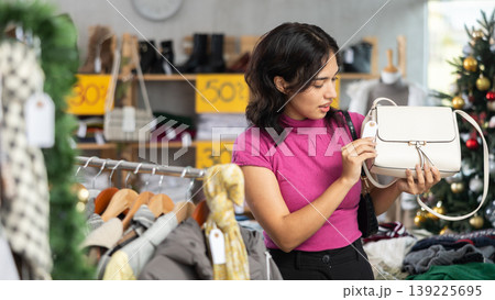Filipino woman chooses a stylish handbag at Christmas sale Filipino woman chooses a stylish handbag at Christmas sale 139225695