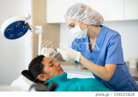 Woman receiving cosmetic facial injection at clinic Woman receiving cosmetic facial injection at clinic 139225828