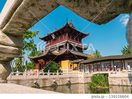Ornate Chinese temple building and corridor over calm water 139226604