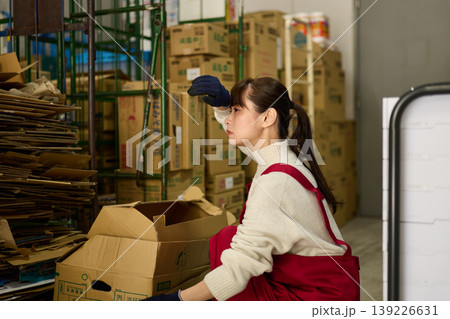 バックヤードでダンボールを片付ける女性 139226631