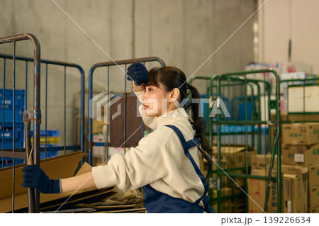 バックヤードでダンボールを片付ける女性 139226634