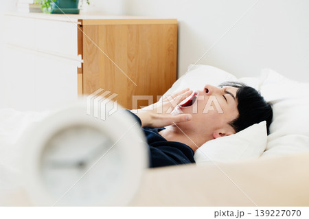 寝坊する若い男性 139227070