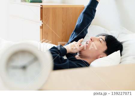 寝坊する若い男性 139227071