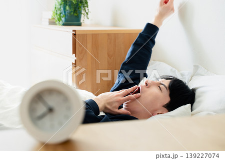 寝坊する若い男性 139227074