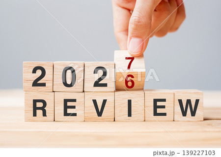 hand flipping block 2026 to 2027 REVIEW text on table. Resolution, idea, goal, motivation, reboot, business and New Year holiday concepts hand flipping block 2026 to 2027 REVIEW text on table. Resolution, idea, goal, motivation, reboot, business and New Year holiday concepts 139227103