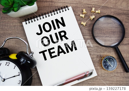 Join Our Team text written on notepad with alarm clock, compass and magnifying glass flat lay on wooden background 139227178