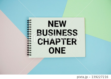 New Business Chapter One text written on notepad flat lay on multicolor pastel background New Business Chapter One text written on notepad flat lay on multicolor pastel background 139227216