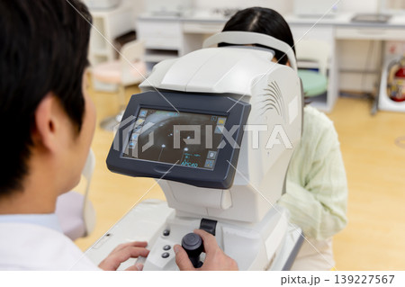 眼科で視力検査を行う医師と患者の診察風景 139227567