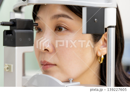 眼科で精密な視力検査を受ける女性のクローズアップ｜老眼・白内障診断 139227605