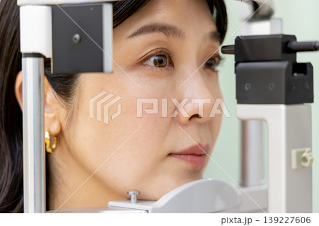眼科で精密な視力検査を受ける女性のクローズアップ｜老眼・白内障診断 139227606