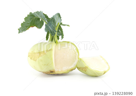 Fresh kohlrabi vegetable cut in half showing its crisp white interior and green leaves 139228090