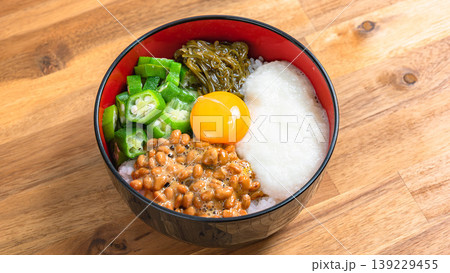ネバネバ丼 納豆とオクラととろろとめかぶと卵黄のご飯 木目背景 139229455