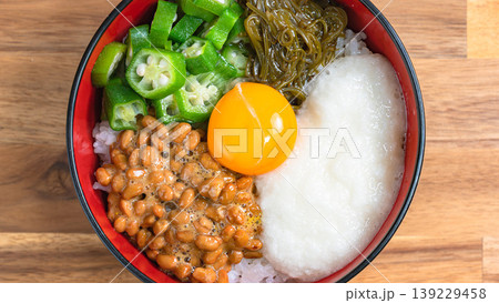 ネバネバ丼 納豆とオクラととろろとめかぶと卵黄のご飯 木目背景 139229458