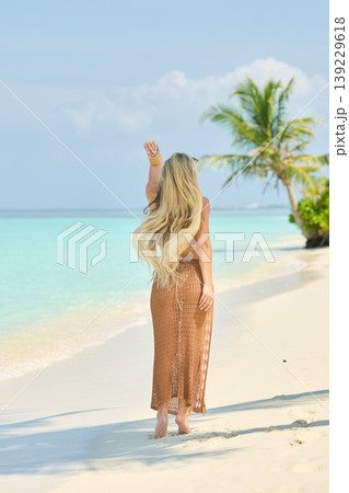 A beautiful tanned girl with an athletic physique in a swimsuit runs on the personal beach of the villa on a sunny day in the Maldives, she is happy and posing A beautiful tanned girl with an athletic physique in a swimsuit runs on the personal beach of the villa on a sunny day in the Maldives, she is happy and posing 139229618