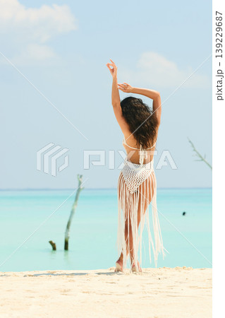 A beautiful tanned girl with an athletic physique in a swimsuit runs on the personal beach of the villa on a sunny day in the Maldives, she is happy and posing A beautiful tanned girl with an athletic physique in a swimsuit runs on the personal beach of the villa on a sunny day in the Maldives, she is happy and posing 139229687