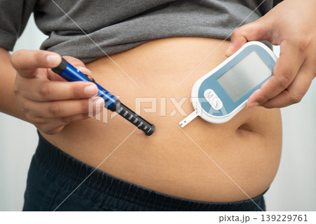 Asian woman injecting herself diabetes injecting insulin in stomach at home. Asian woman injecting herself diabetes injecting insulin in stomach at home. 139229761
