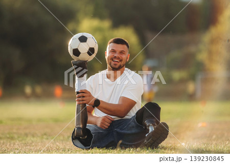 Soccer ball is on the shoe, having fun. Strong amputee man with prosthesis is on the field Soccer ball is on the shoe, having fun. Strong amputee man with prosthesis is on the field 139230845