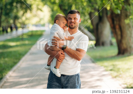 Conception of love and care, standing. Father that is amputee with prosthesis is with his little son in the park 139231124