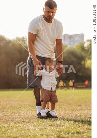 Bright sunlight, illuminated by it. The amputee father is with his son on the field Bright sunlight, illuminated by it. The amputee father is with his son on the field 139231149