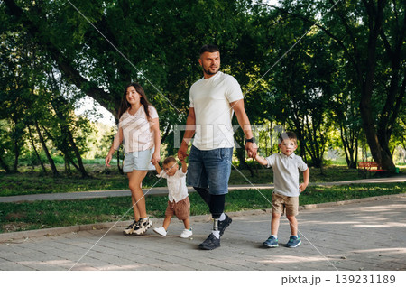 In the public park. Family of father that is amputee with prosthesis, mother and two kids 139231189