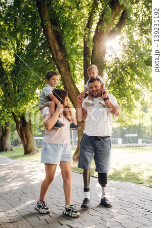 Family of father that is amputee with prosthesis, mother and two kids Family of father that is amputee with prosthesis, mother and two kids 139231192