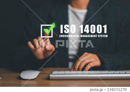 A business professional interacts with a digital interface highlighting ISO 14001, emphasizing environmental management systems. 139231270