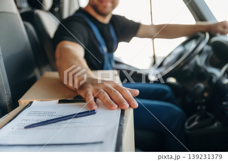 Just formal stuff, the notepad with document, invoice. Inside of the bus with delivery service man in uniform Just formal stuff, the notepad with document, invoice. Inside of the bus with delivery service man in uniform 139231379
