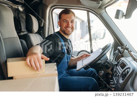 Checking the package. Inside of the bus with delivery service man in uniform Checking the package. Inside of the bus with delivery service man in uniform 139231407