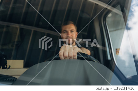 Front view of delivery man that is driving a van Front view of delivery man that is driving a van 139231410