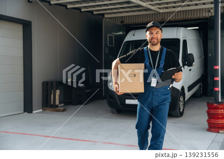 Delivery man is by the bus near garage outdoors 139231556