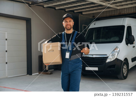 Delivery man is by the bus near garage outdoors Delivery man is by the bus near garage outdoors 139231557
