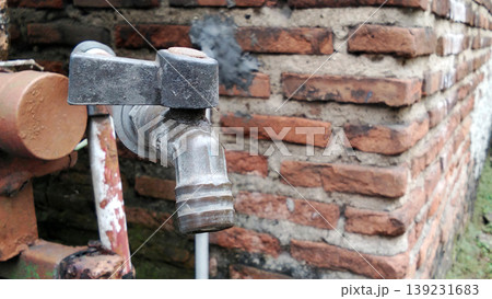 Old Water Tap on Brick Wall with Textured Details Old Water Tap on Brick Wall with Textured Details 139231683