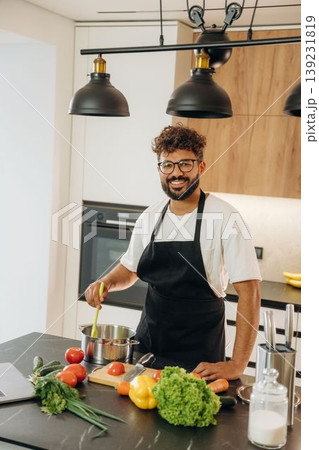 Handsome man is preparing food on the kitchen 139231819