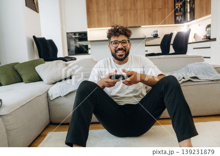 Enjoying playing video games, with controller. Man is in the modern domestic room at home 139231879