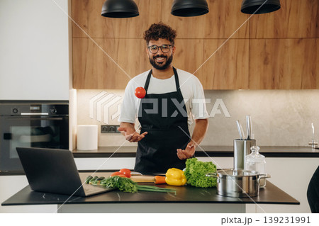 Fresh vegetables, making salad. Handsome man is preparing food on the kitchen Fresh vegetables, making salad. Handsome man is preparing food on the kitchen 139231991