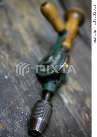 Drill tool old style with hand human energy in green over  wood table 139232018